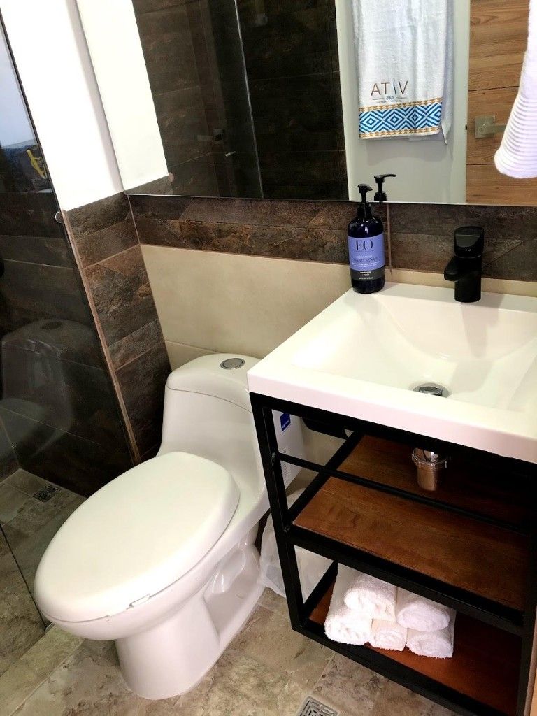 Bathroom with toilet, vanity sink, and folded towels in an El Rodadero Santa Marta apartment